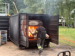 ein Feuerwehrmann übt an einem brennenden Container