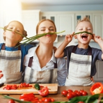 junge Mutter mit Tochter und Sohn beim Salatzubereiten in der K&uuml;che