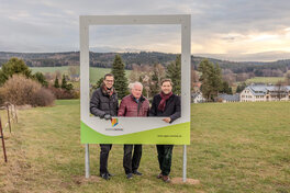 Beigeordneter Mario Müller, Frieder Flechsig und Bürgermeister Christfried Nicolaus (v. l.) schauen durch den Bilderrahmen