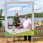 Landrat Carsten Michaelis und Oberb&uuml;rgermeister S&ouml;ren Kristensen stehen im Bilderrahmen vor der Kulisse der Koberbachtalsperre
